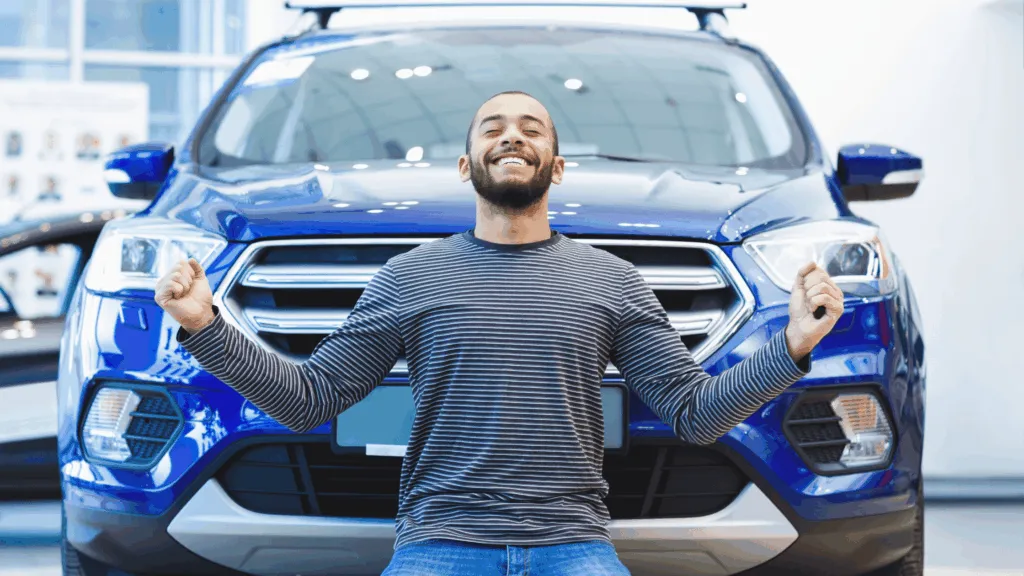 Happy man in front of a car to augment the article about getting a cheap rent to buy cars.