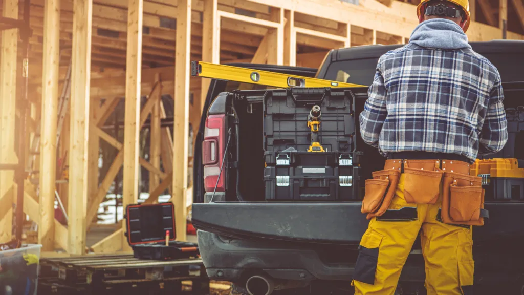 Image of a construction worker at a site using a bakkie to augment the blog article which is titled Rent to Buy Cars for Self Employed People